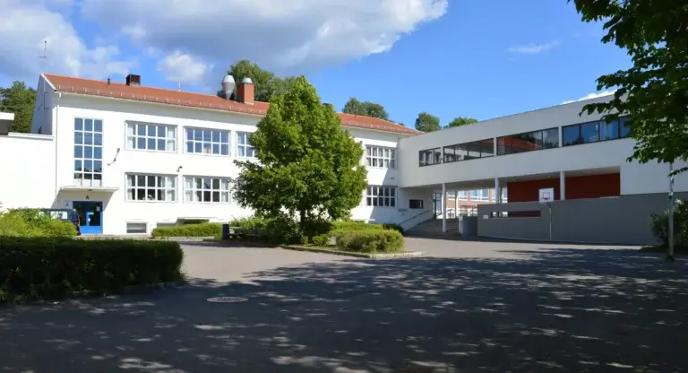 en skole i norge med gront rundt bygningene