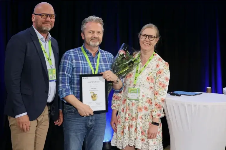 Odin Nøsen fekk årets Gulleplepris. På bilete er den populære vinnaren flankert av juryleiar Bente Moen Kristiansen og Tore Mydland, begge frå NPeD.