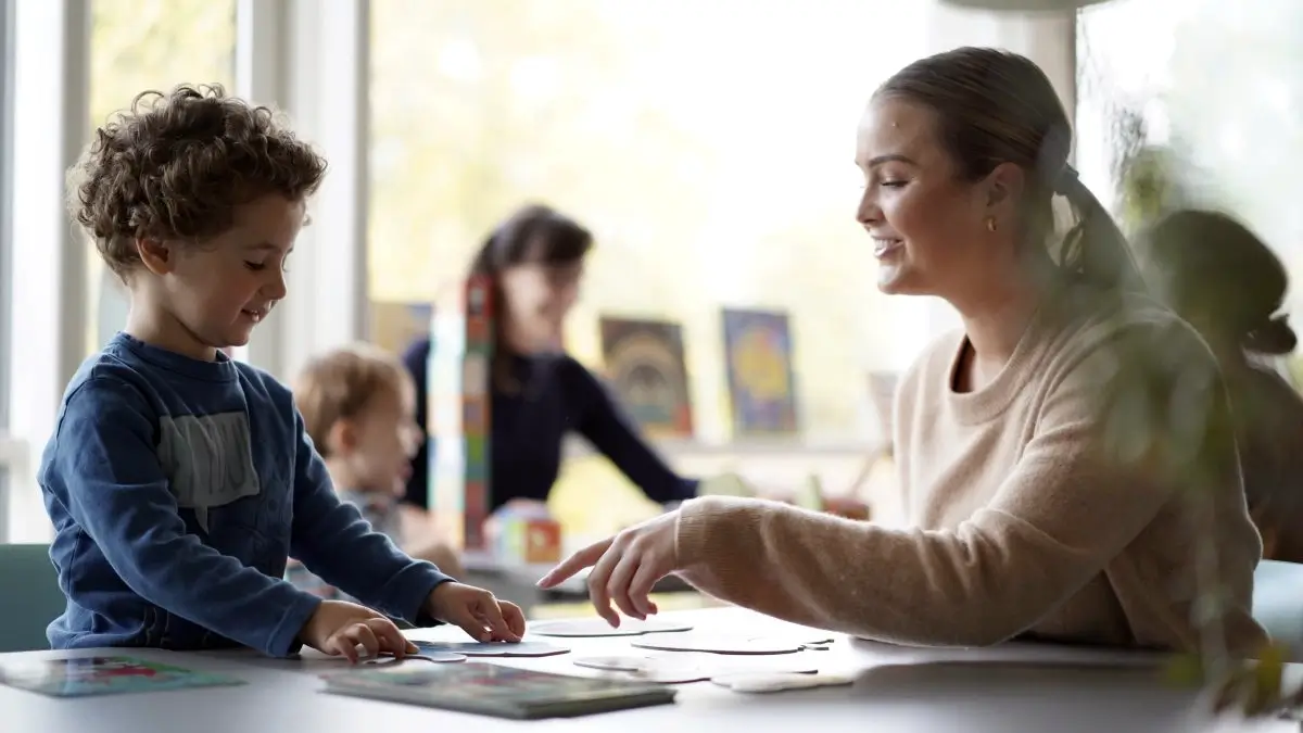 barnehagelaerer med lite barn pusler puslespill