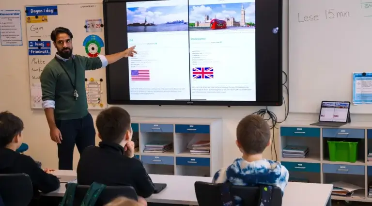 laerer underviser i klasserom pa barneskole ved hjelp digital tavle