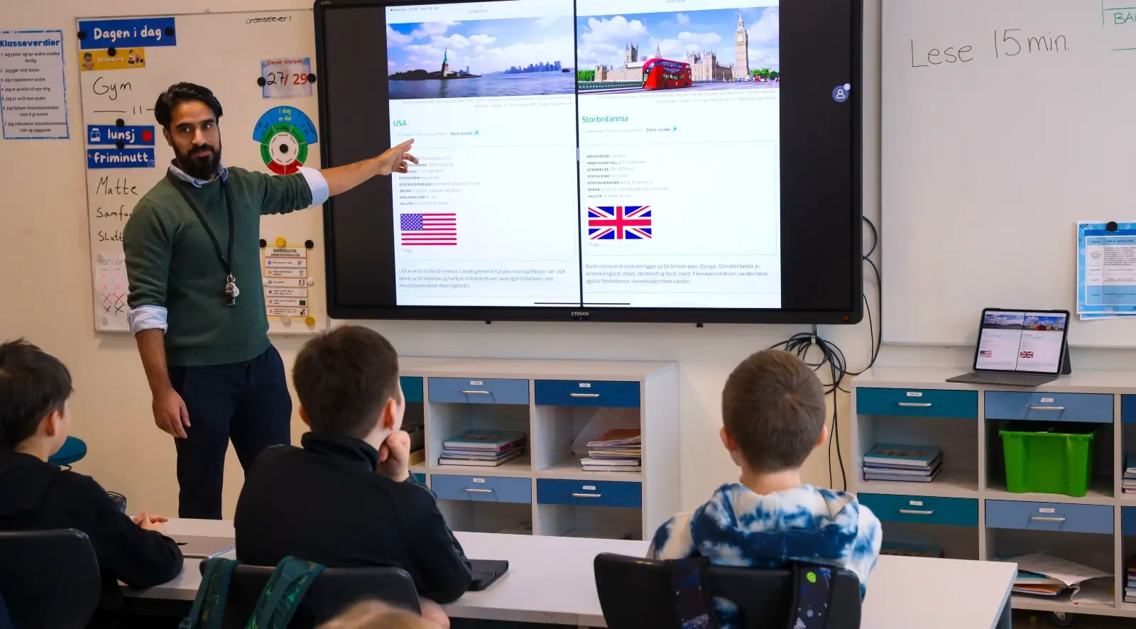 laerer underviser i klasserom pa barneskole ved hjelp digital tavle