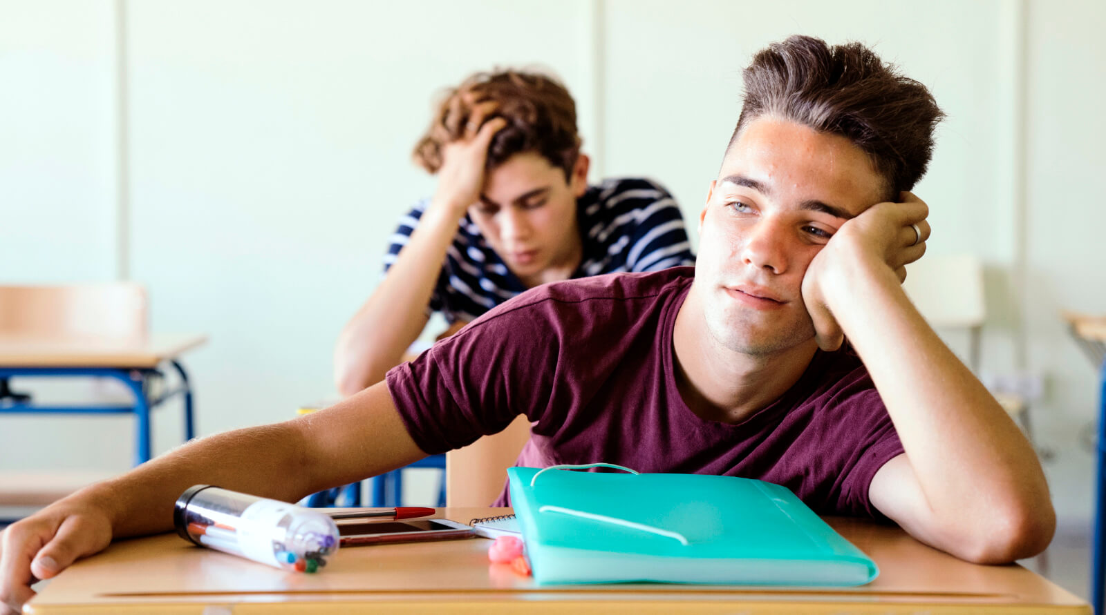 Trøtte skoleelever i klasserom
